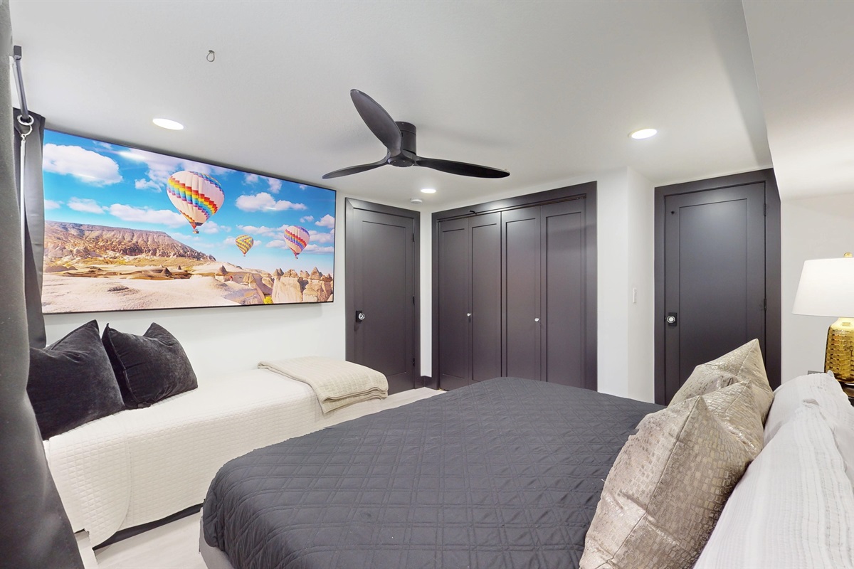 Lower level Primary Bedroom with King bed, twin bed, and 85: SmartTV.