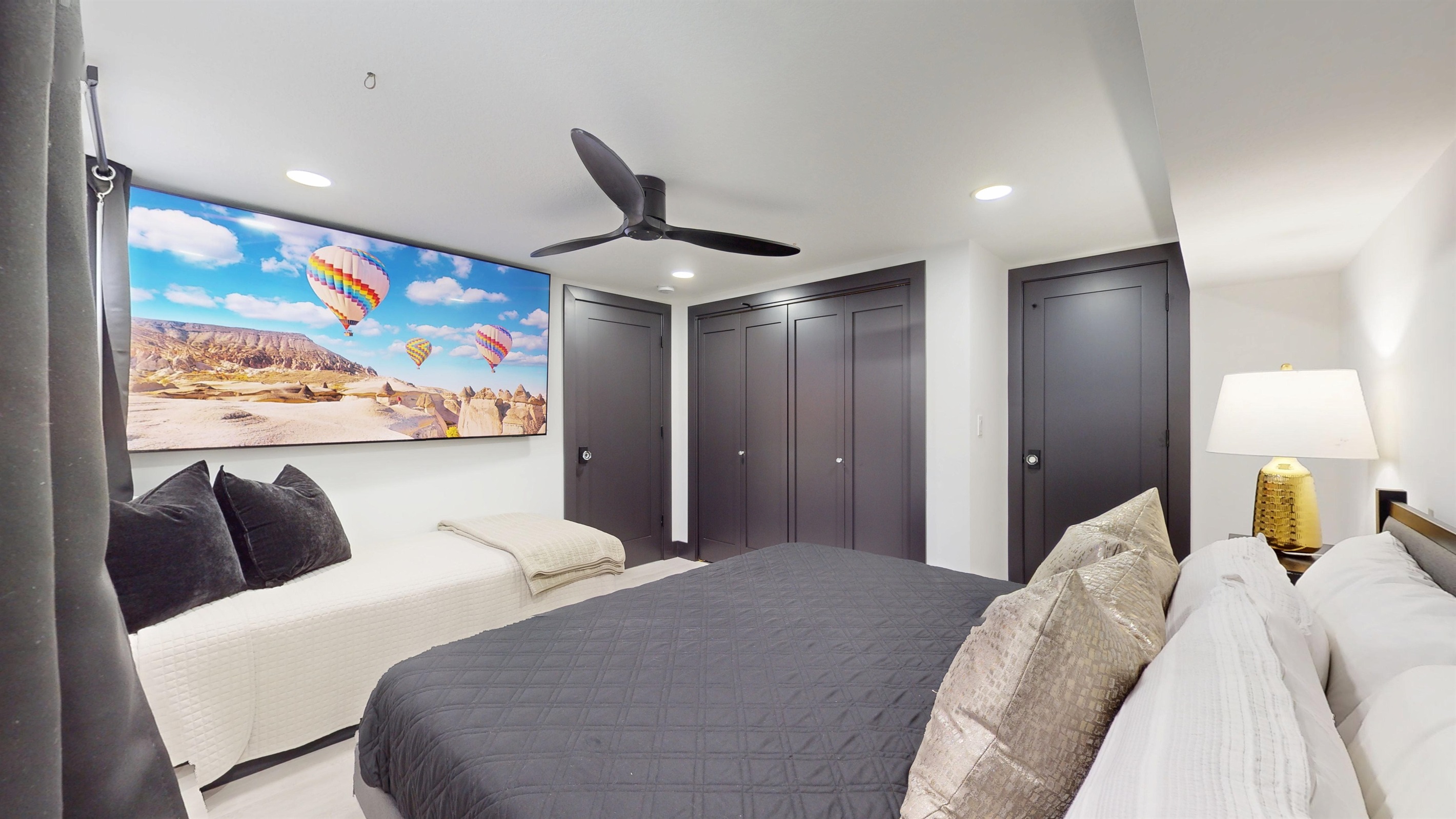 Lower level Primary Bedroom with King bed, twin bed, and 85: SmartTV.
