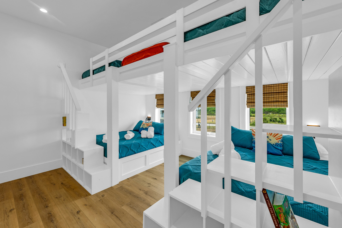 Cair Paravel: A closer look at the custom bunk beds, dressed in teal quilted bedding with playful coral accents, sleeping arrangements that feel like an adventure.