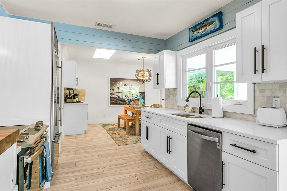 The fully stocked kitchen boasts a Sub-Zero fridge and acacia wood butcher block counters. A peninsula with seating provides the perfect spot for casual meals or morning coffee.