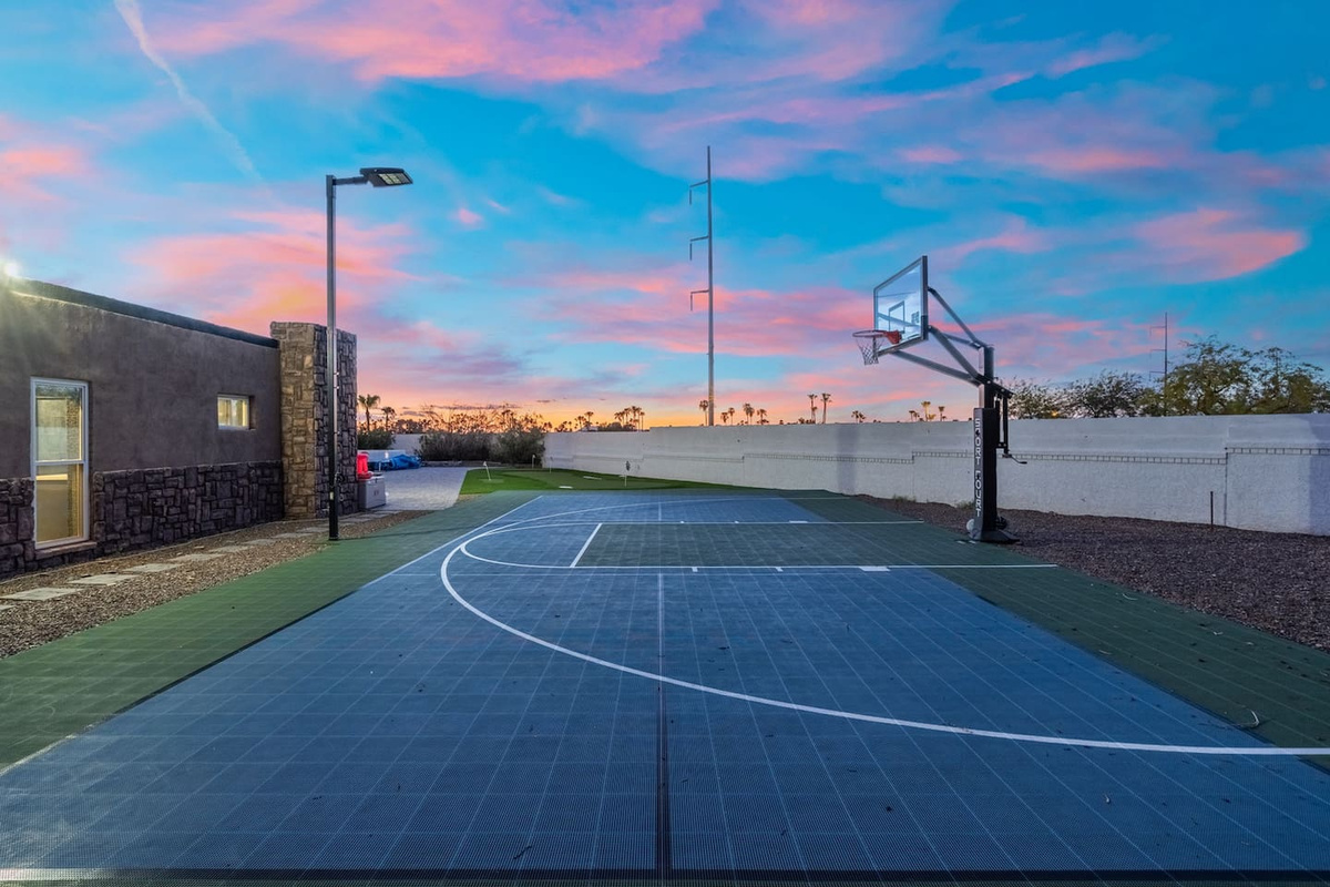 The private basketball court glows under a vivid desert sunset — game time never looked so good.