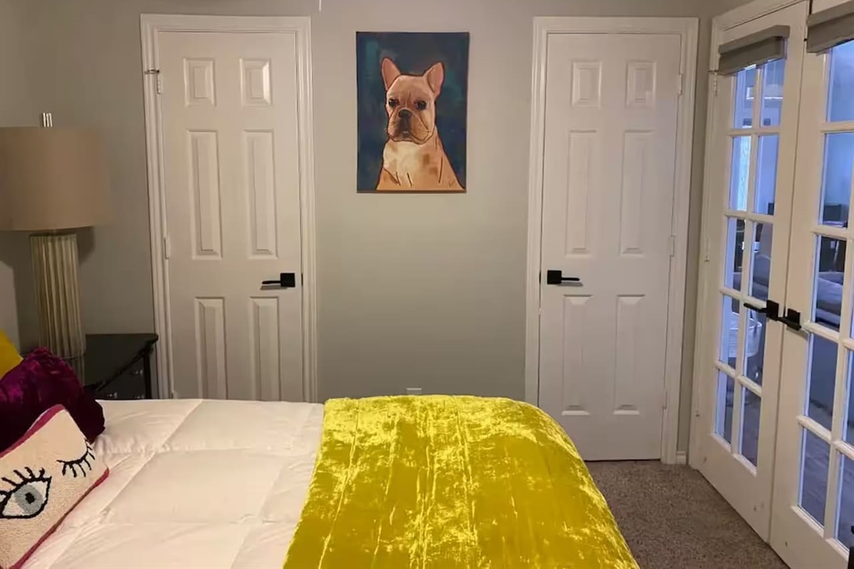 Bedroom with queen bed and bold yellow bedding.