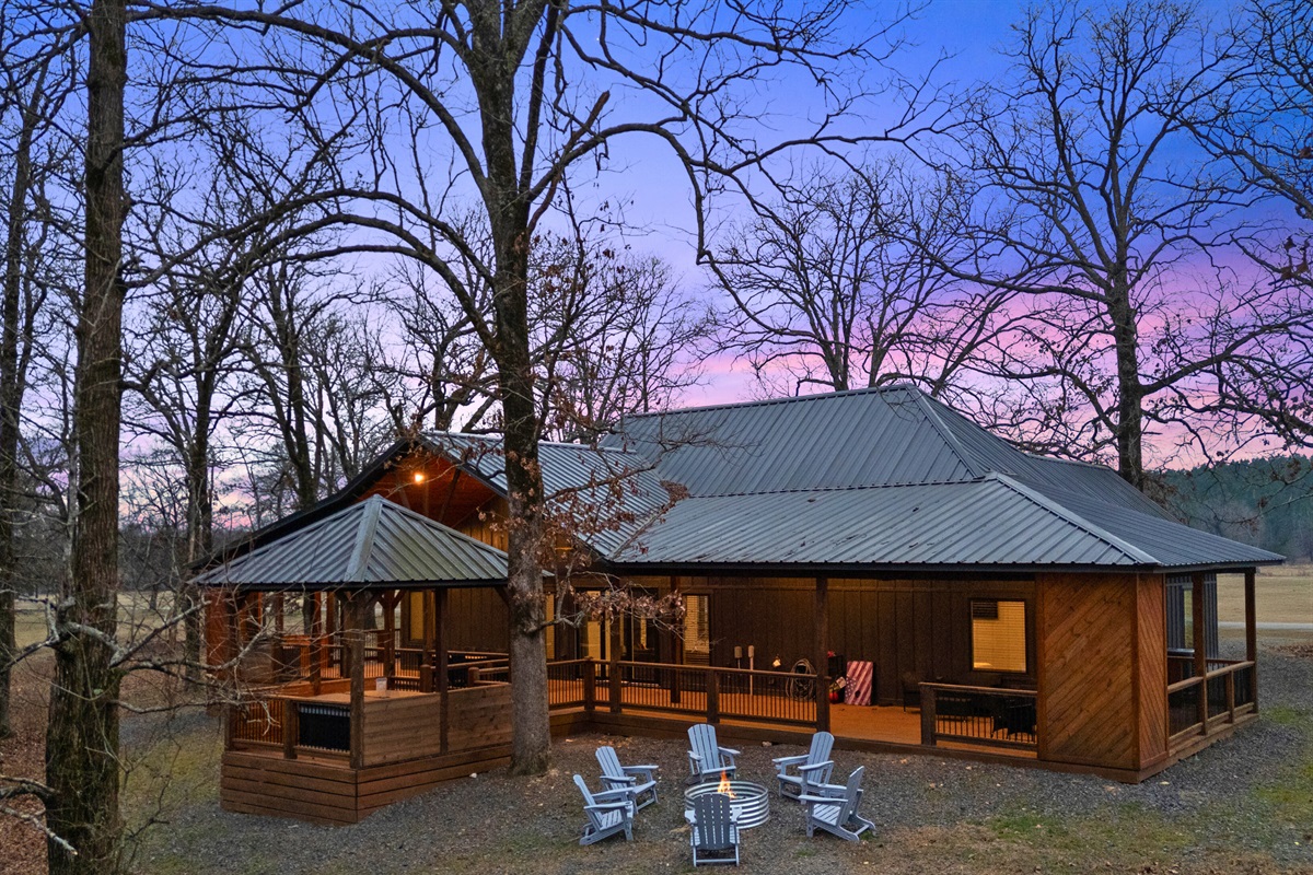 As the sun sets, the cabin glows beautifully in the trees, creating that cozy evening feeling you come to Broken Bow for.