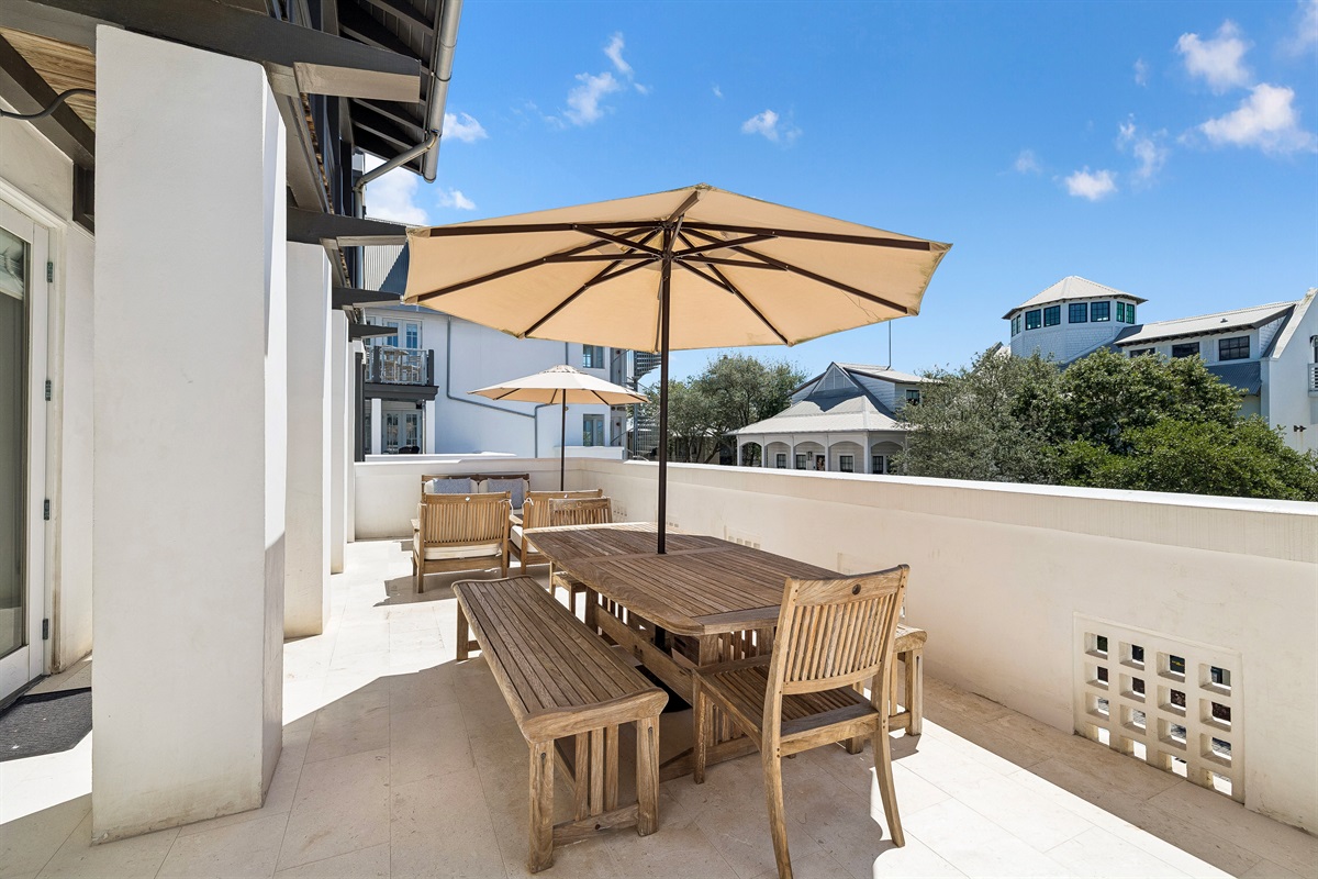 The oversized terrace offers lounge space, a large dining table, and sun loungers for private sun-bathing.