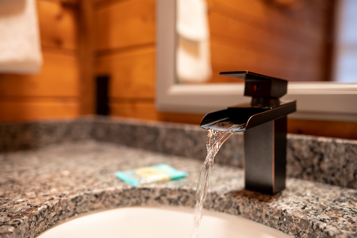 Modern vanity with granite counter and sleek black faucet.