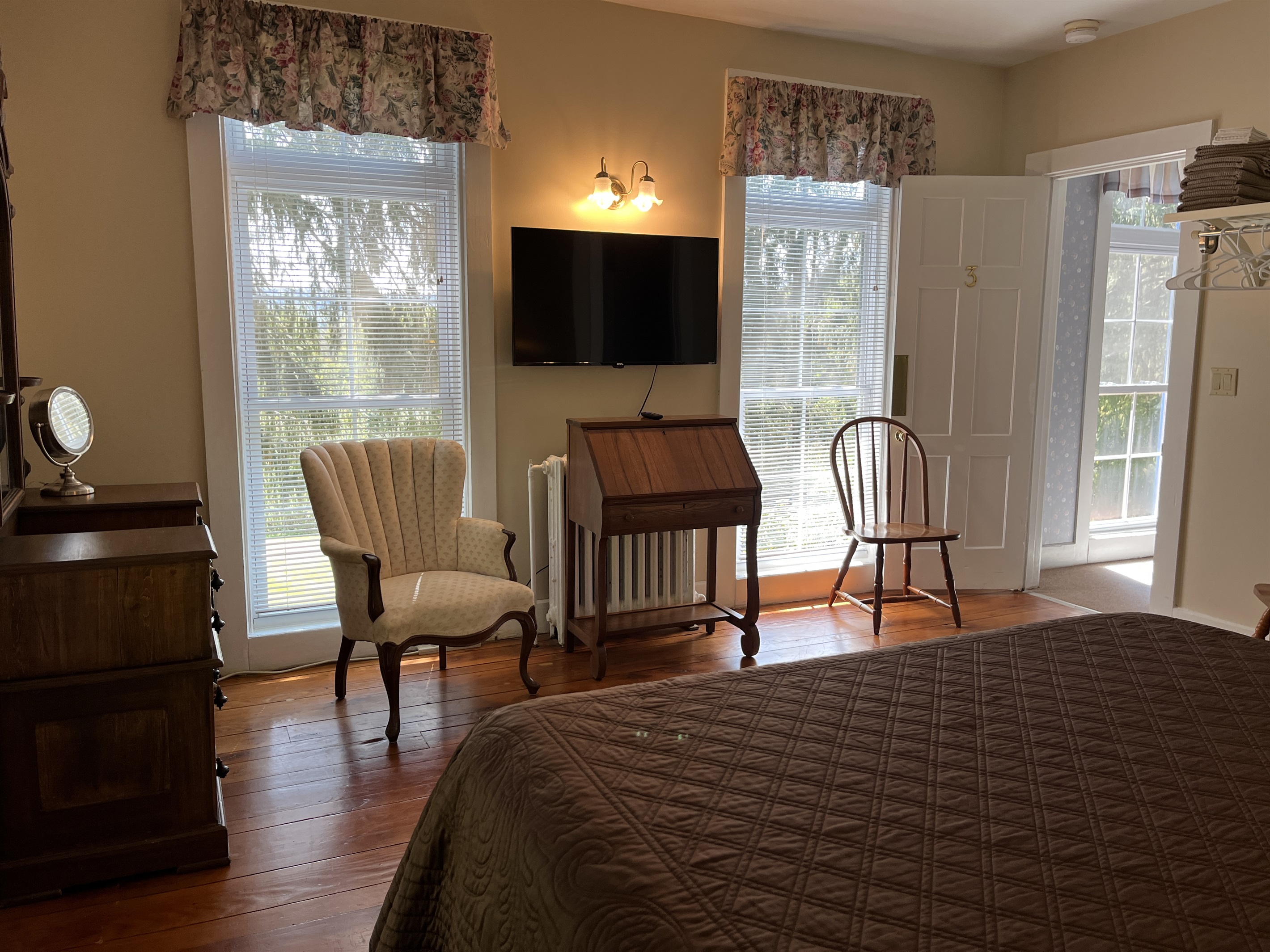 2nd floor bedroom #4 w/ desk and TV. Doorway leading to the hallway on the right.