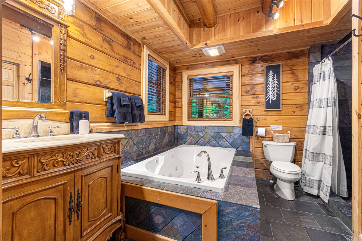 Main Level Master Bathroom: Indulge in a luxurious soak with stunning wood and stone accents!
