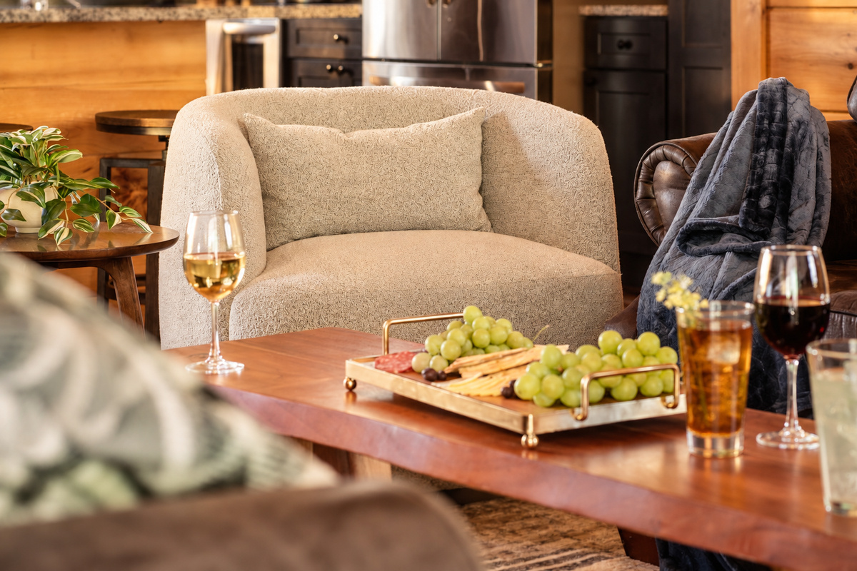 Sink into a curved armchair with a glass of wine by the live-edge coffee table.