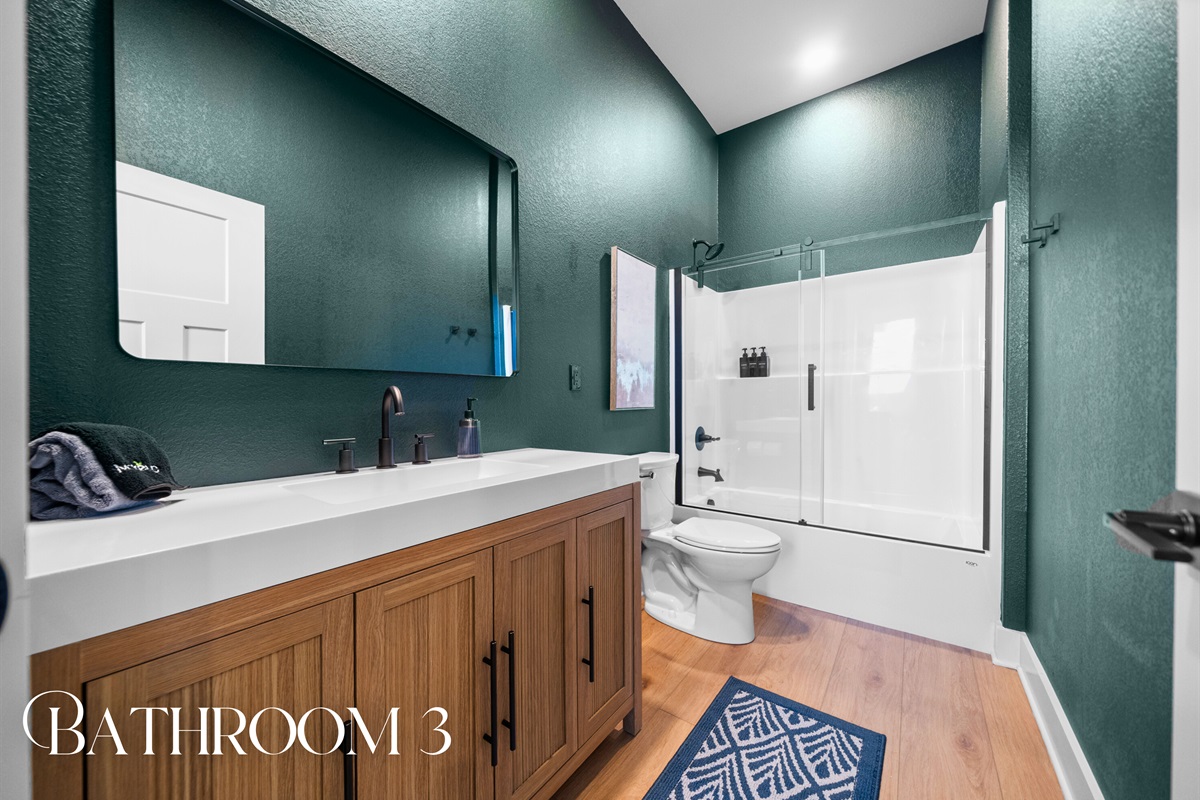 Bathroom three pairs rich tones with modern finishes, creating a stylish and functional space for guests.