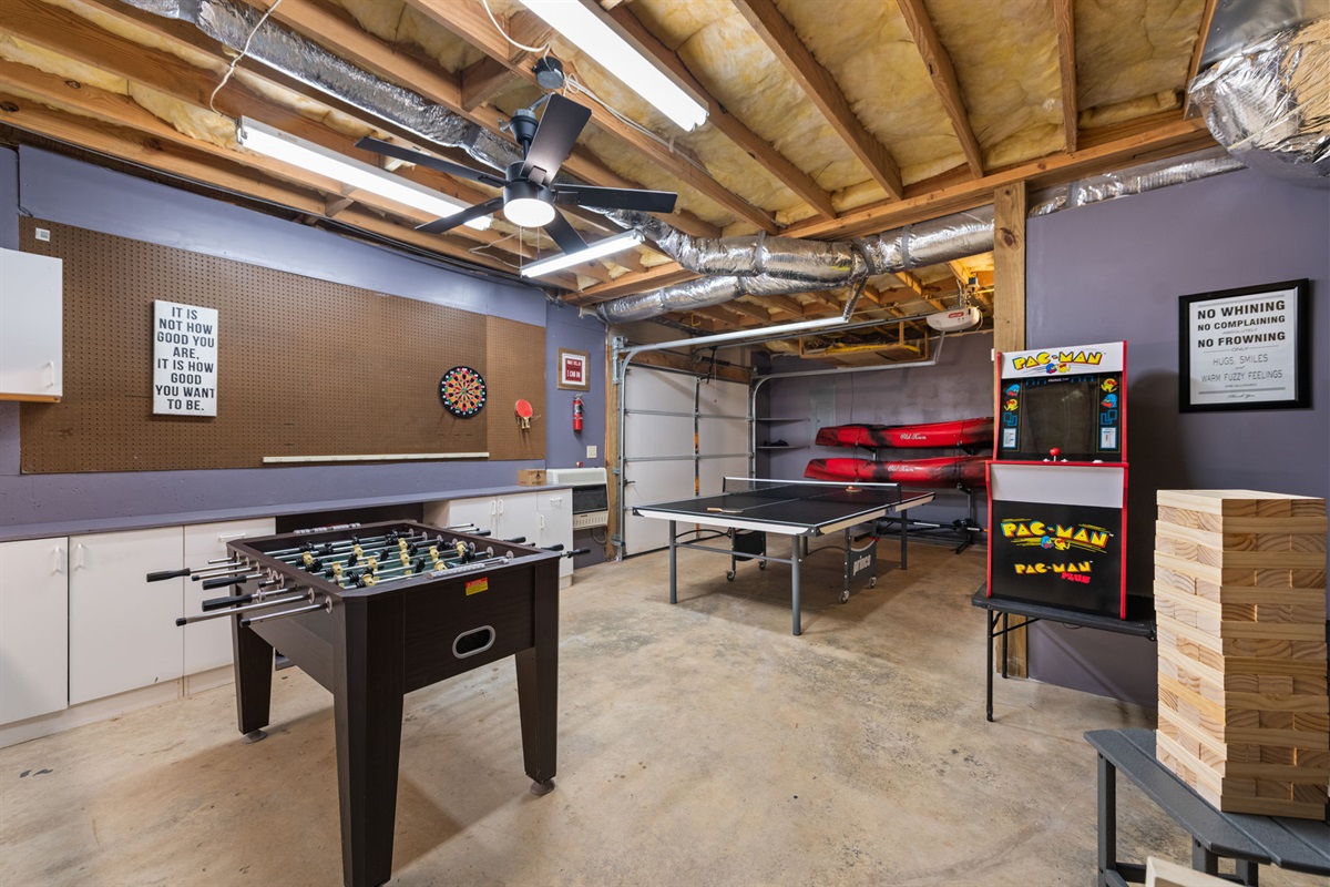The converted garage game room is packed with fun, offering table tennis, arcade games, foosball, and darts for endless entertainment.