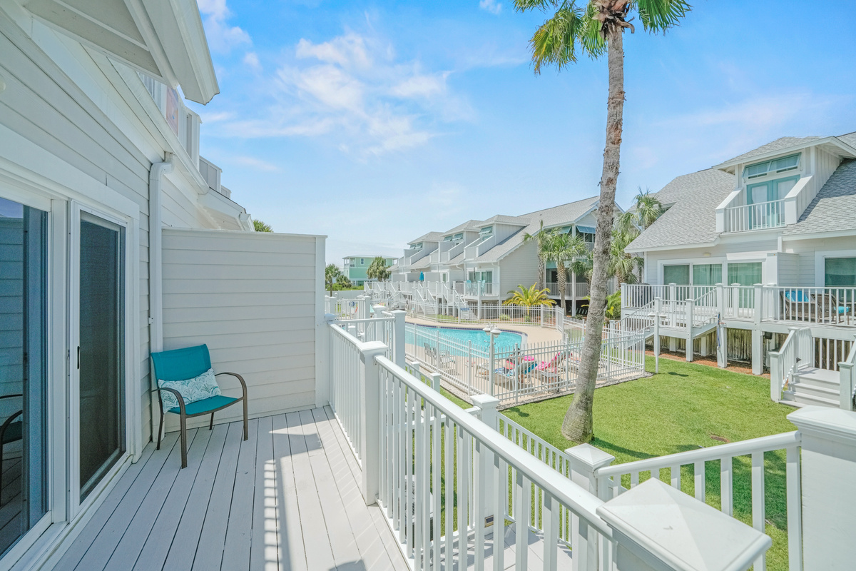 Bright balcony with comfortable seating overlooking the pool area