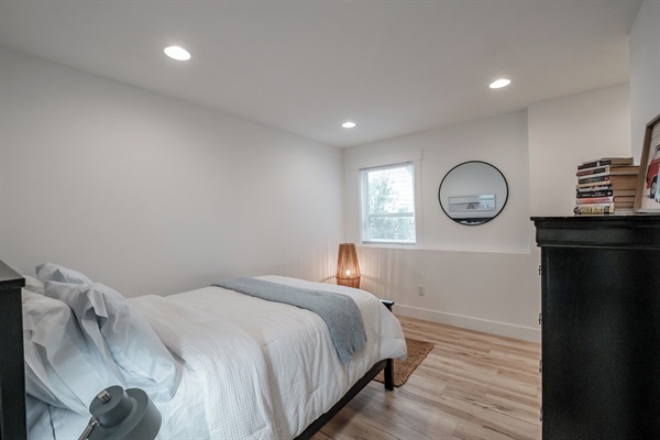 This serene bedroom offers gentle natural light and a relaxing atmosphere for a restful stay. 