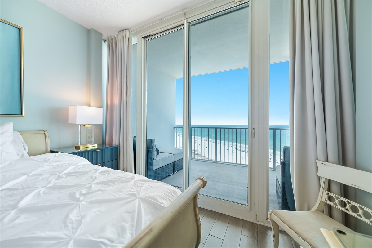 Enjoy breathtaking ocean views from this spacious Primary bedroom featuring a comfortable king-size bed, ample storage, and direct access to a private balcony.