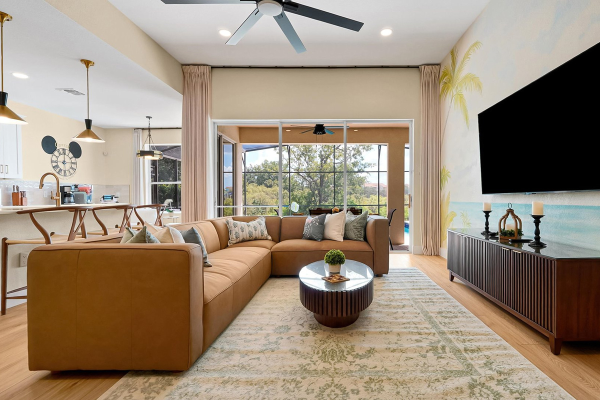 Living Room: Comfortable family gathering space with a large TV, hand-painted tropical mural and peaceful conservation views.
