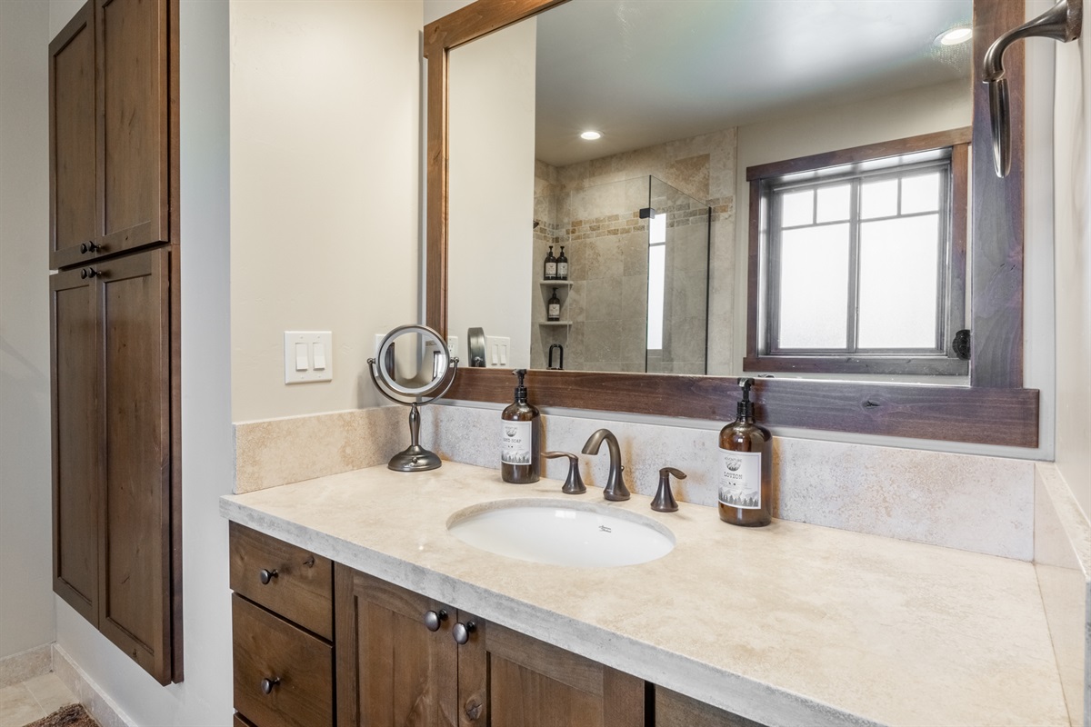 A spacious vanity in the primary ensuite at Bear’s Den provides plenty of room to get ready, stocked with our signature hand-poured guest toiletries.