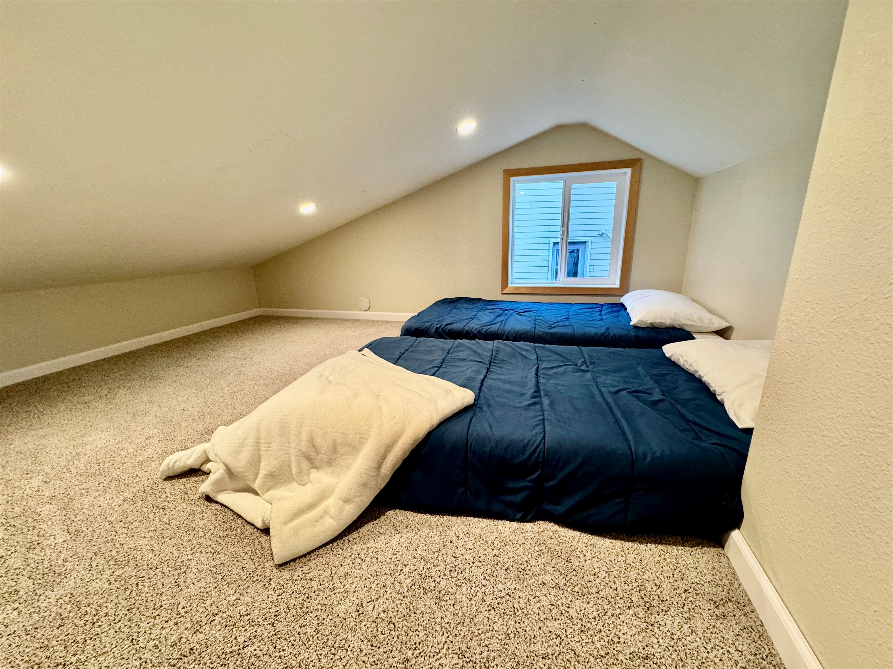 2 twin beds at top of spiral staircase in loft