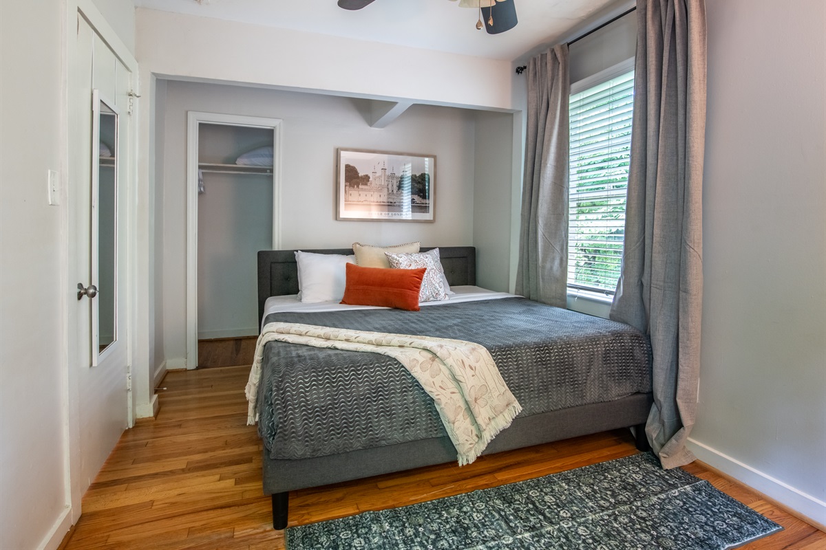 Inviting queen bedroom with cozy bedding, thoughtful decor, and natural light.
