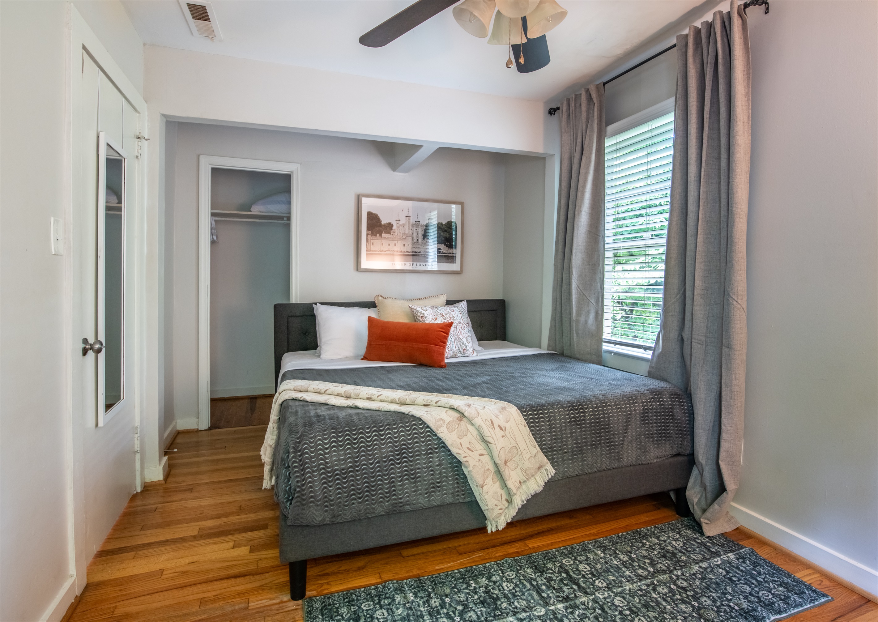 Inviting queen bedroom with cozy bedding, thoughtful decor, and natural light.