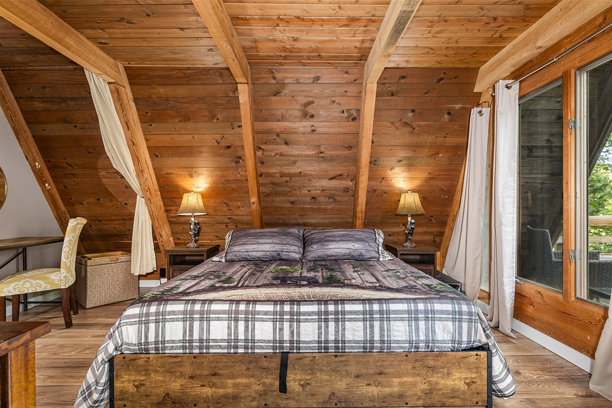 Discover the first-floor sleeping space with king bed flanked by beside tables.