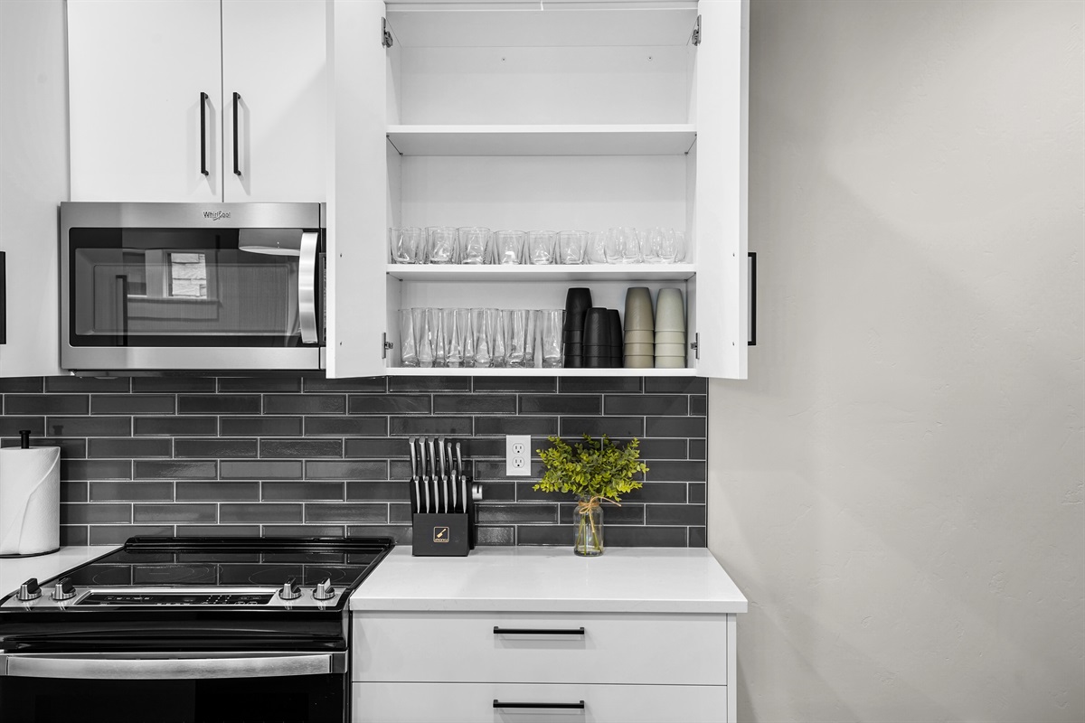 Stay organized in this modern kitchen featuring fully stocked glassware cabinets.