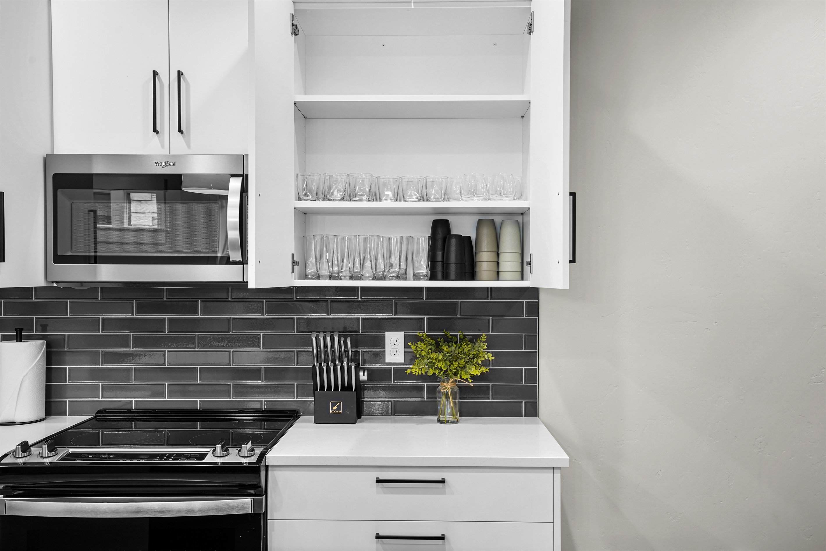 Stay organized in this modern kitchen featuring fully stocked glassware cabinets.
