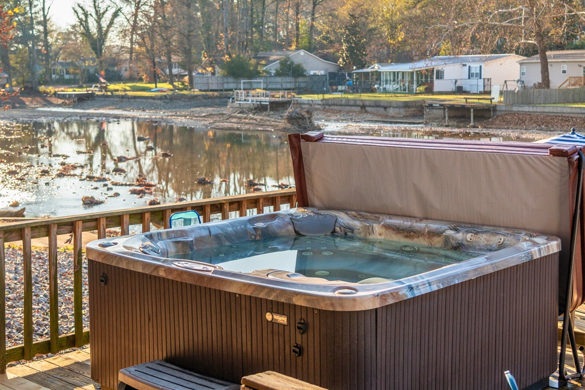 The hot tub sits just steps from the water, offering a serene place to unwind and enjoy the peaceful lakeside atmosphere day or night.