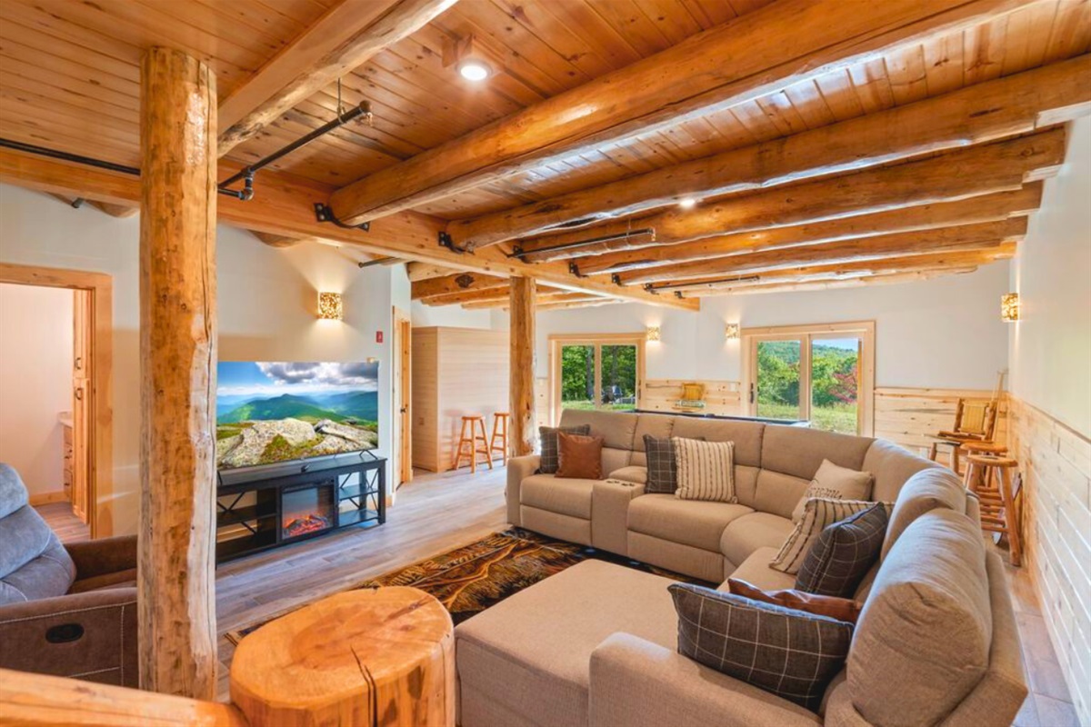 Entertainment-ready basement with sectional and TV.