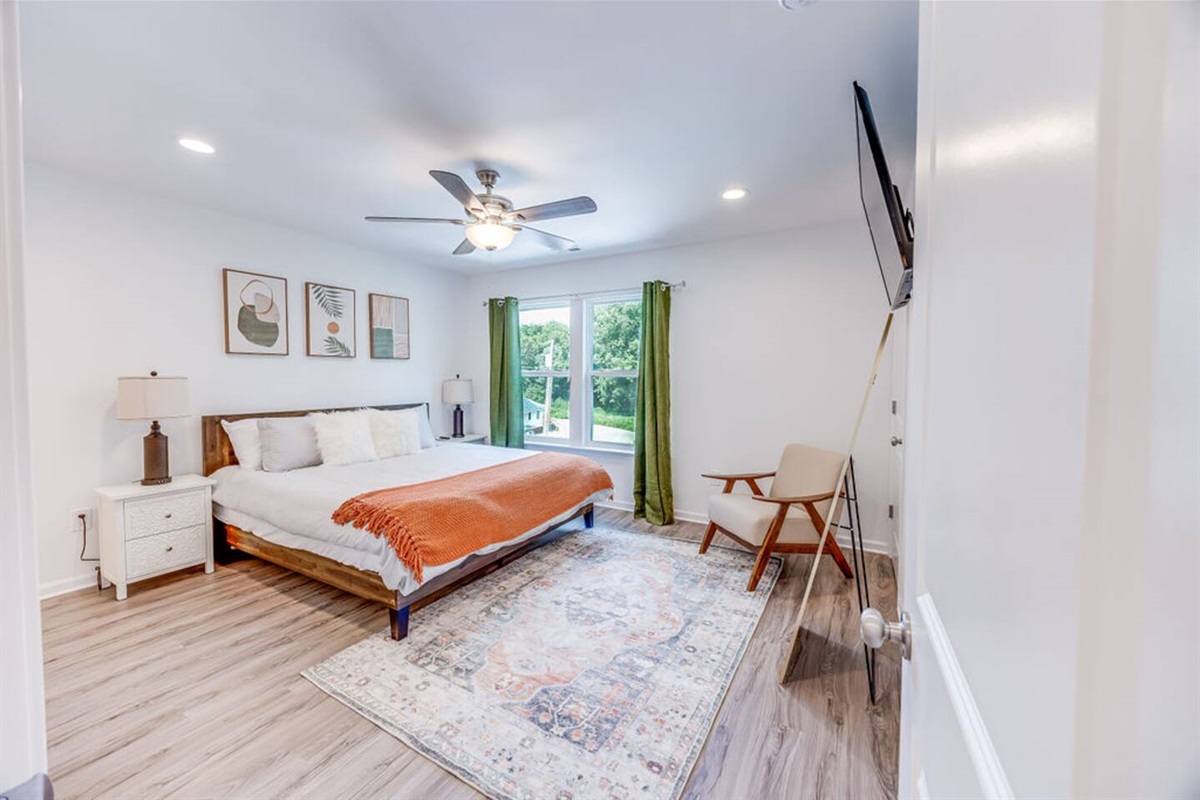 Unwind in the master bedroom, complete with a cozy seating area and a TV for ultimate relaxation and comfort.