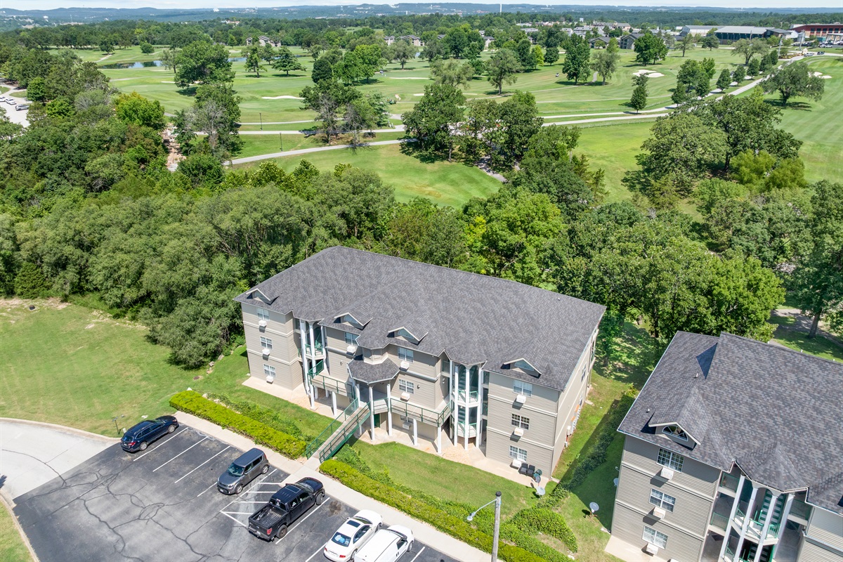Aerial view of the building backed by Holiday Hills golf greens, showing the peaceful resort setting around the condo.