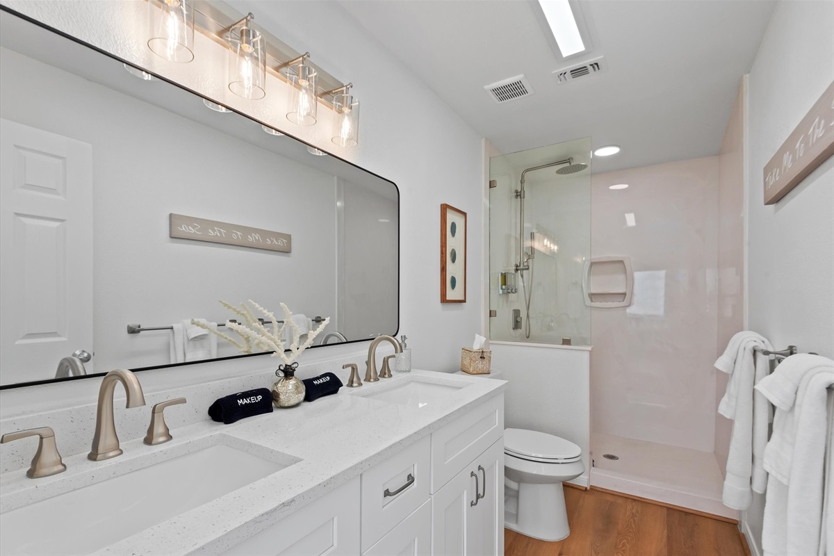 The ensuite bathroom features double sinks and a luxurious walk-in shower.