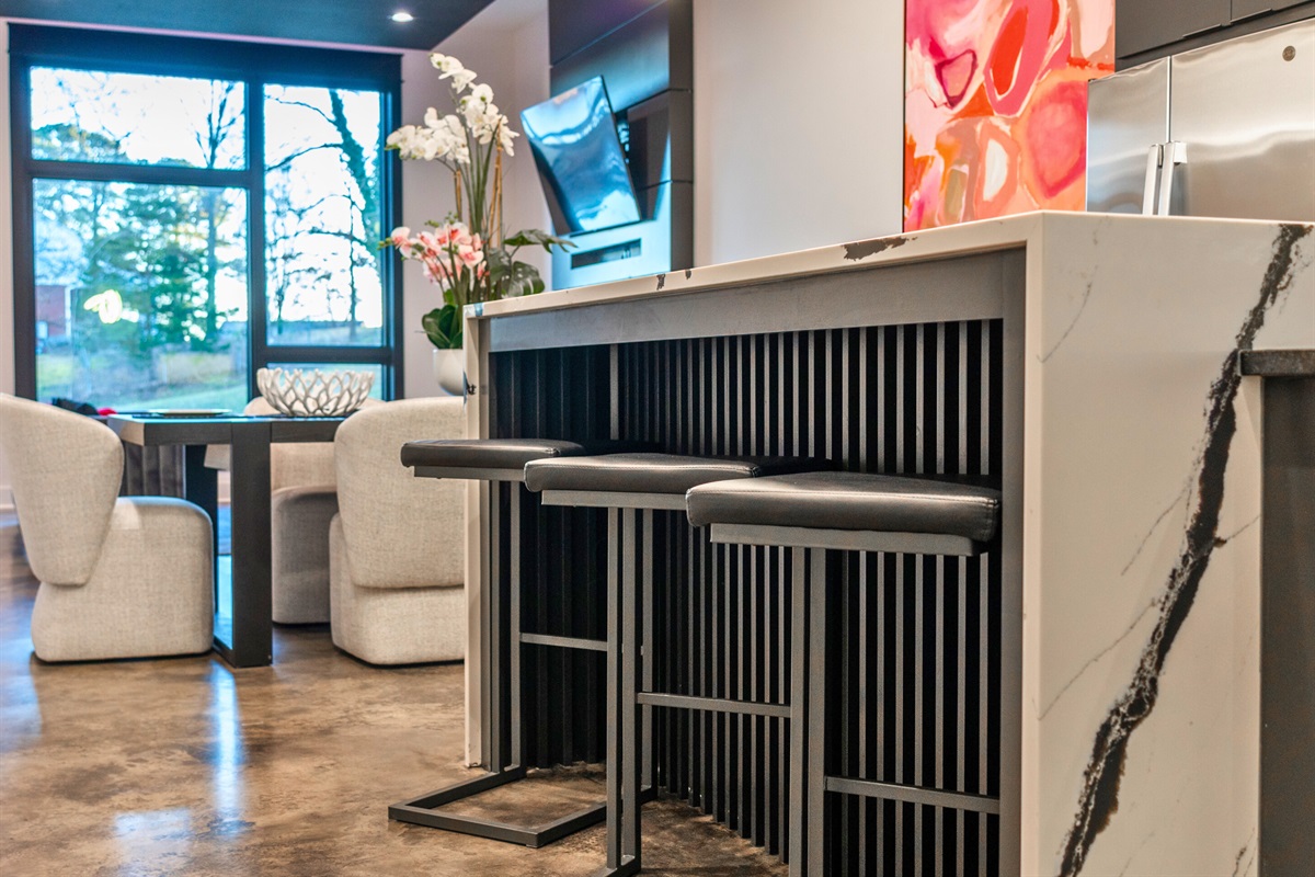 The stylish bar area offers comfortable seating, a polished island, and a seamless connection to the rest of the home, making it perfect for casual meals or morning coffee.