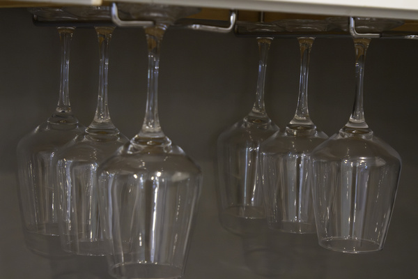 Wine glasses hung under cabinet in the kitchen