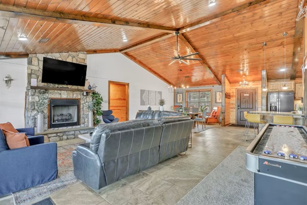 Open-concept living, dining, and kitchen area—designed for gathering and comfort with a shuffleboard table for a little friendly competition.