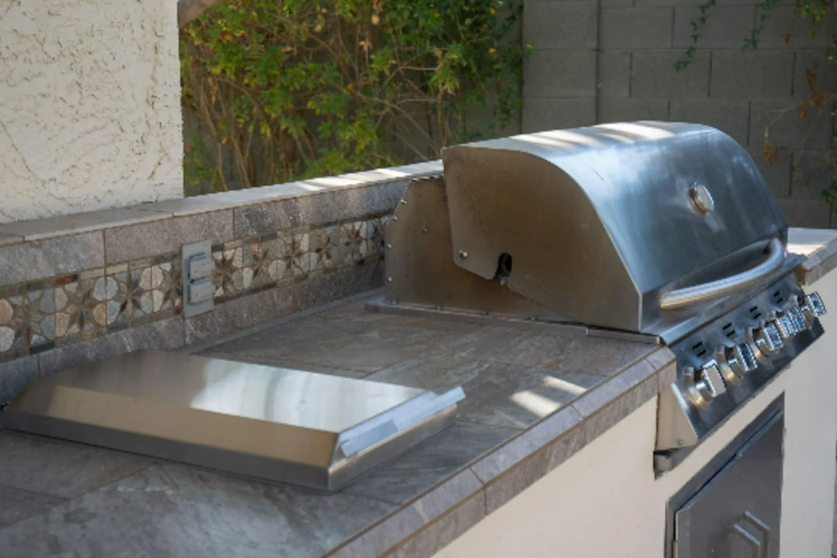 A built-in stainless grill makes outdoor cooking effortless, ready for burgers, steaks, or whatever the group's craving.