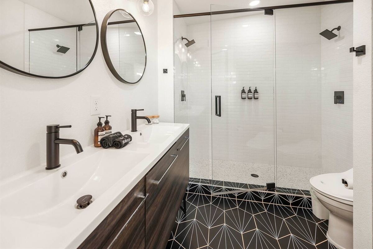 Luxurious spa style bathroom with dual vanity and oversized walk in shower with dual shower heads and a bidet.