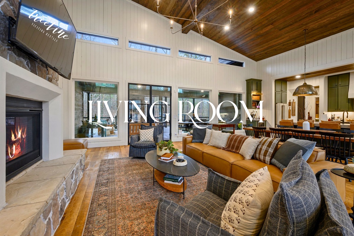 The living room opens up beautifully with tall ceilings, a modern fireplace, and plush seating ideal for gathering with your group.