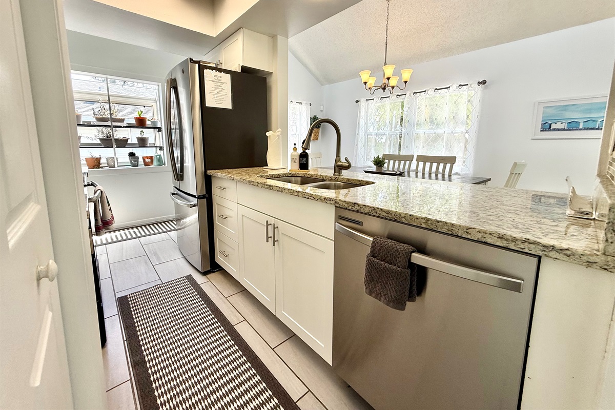 Granite counters and a modern backsplash give this kitchen a fresh, coastal-inspired look.
