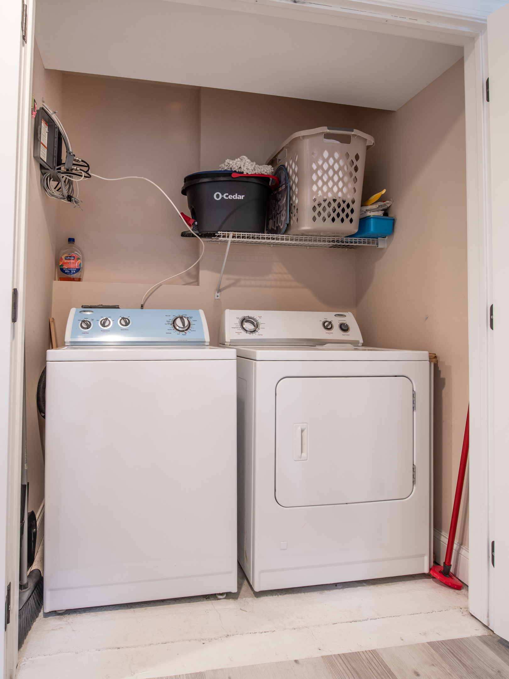 Laundry Closet Equipped with Washer, Dryer, and Storage Shelving