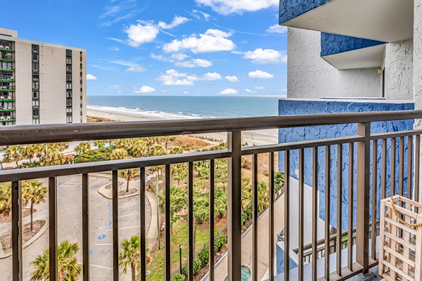 Balcony view overlooking the pool, palm trees, and Atlantic Ocean — enjoy the fresh sea air from your private outdoor space