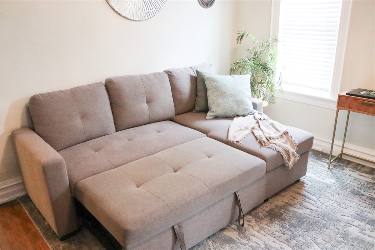extra bedding and pillows stored under chaise 