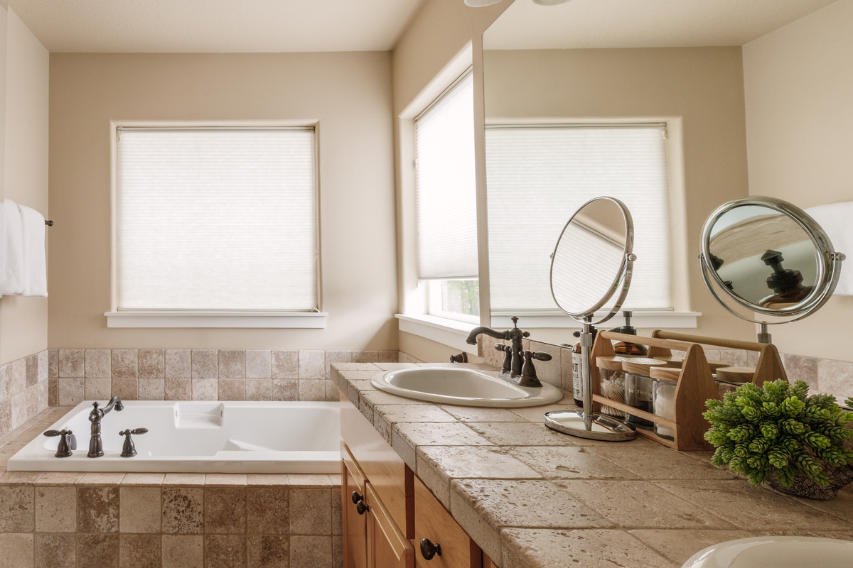 Bright, spacious bathroom with double sinks, warm finishes, and a calm, spa-like feel for easy mornings together.