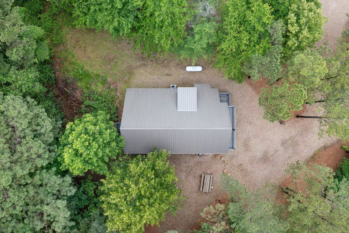 Exterior Retreat: Embrace nature with a serene view and rustic charm surrounded by lush trees!