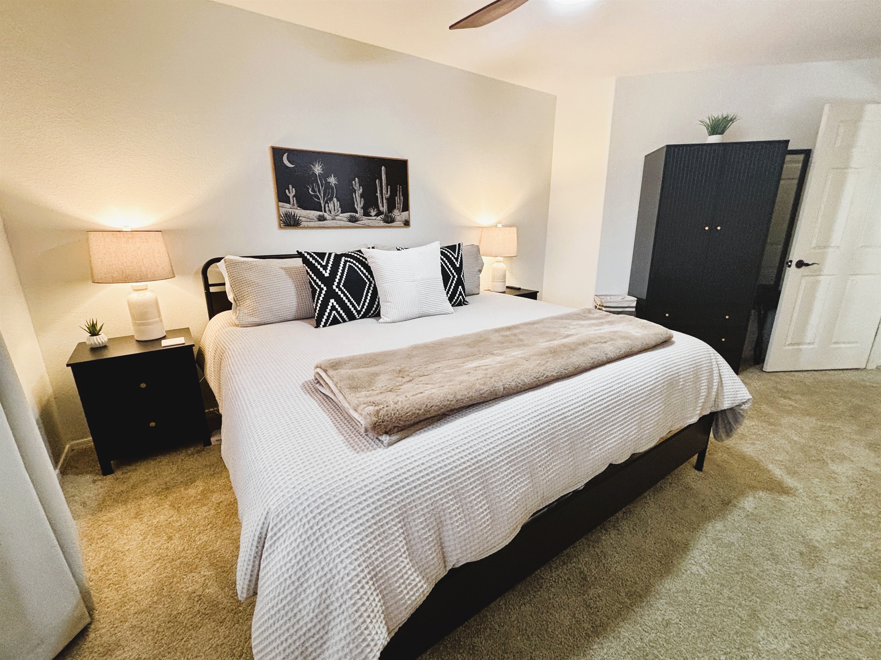 Bedroom with king bed, smart TV, ceiling fan, blackout curtains and linens