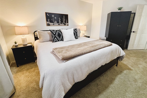 Bedroom with king bed, smart TV, ceiling fan, blackout curtains and linens