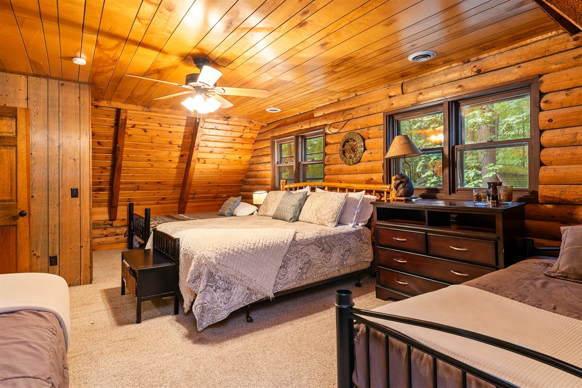Bedroom #4 Inviting bedroom with a King, 2 double beds and an additional twin, rustic wood walls, and a comfortable, homey atmosphere.