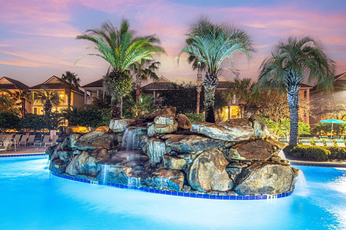 The resort pool lit up at night — pure vacation magic