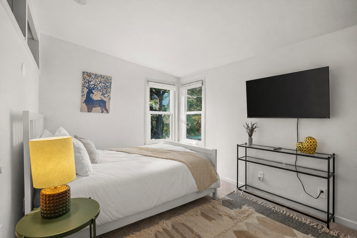 This inviting bedroom features a comfortable queen bed, Smart TV, and a spacious armoire for clothing and storage. It's a cozy, well-appointed space designed for a relaxing and comfortable stay.