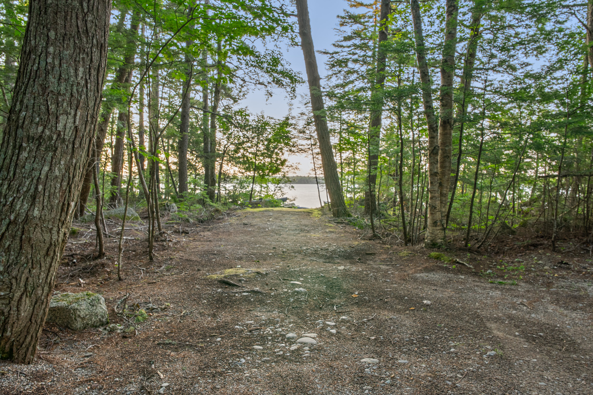 Wide trailer parking lane at Loonrise Point! Long, flat dirt and gravel path provides easy pull-in space for boat trailers, leading straight down to the beachy water entry on Beech Hill Pond in Otis, ME. Easy launching for your watercraft!