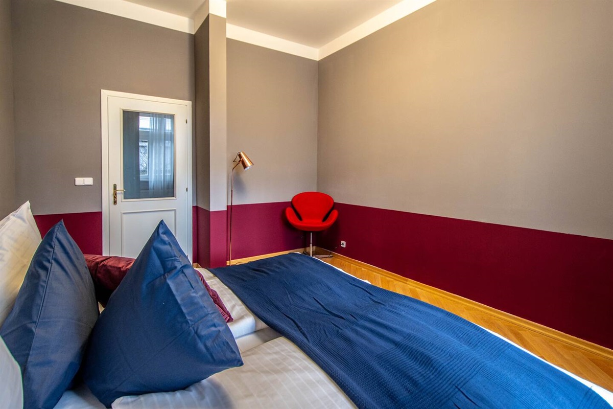 There is a lamp near the red chair to help you to work or read something in the evening time. 