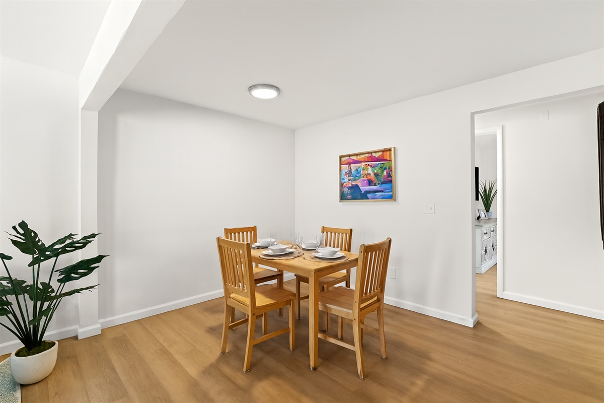 A warm, welcoming dining nook with modern lighting and abstract artwork—great for shared meals or remote work.